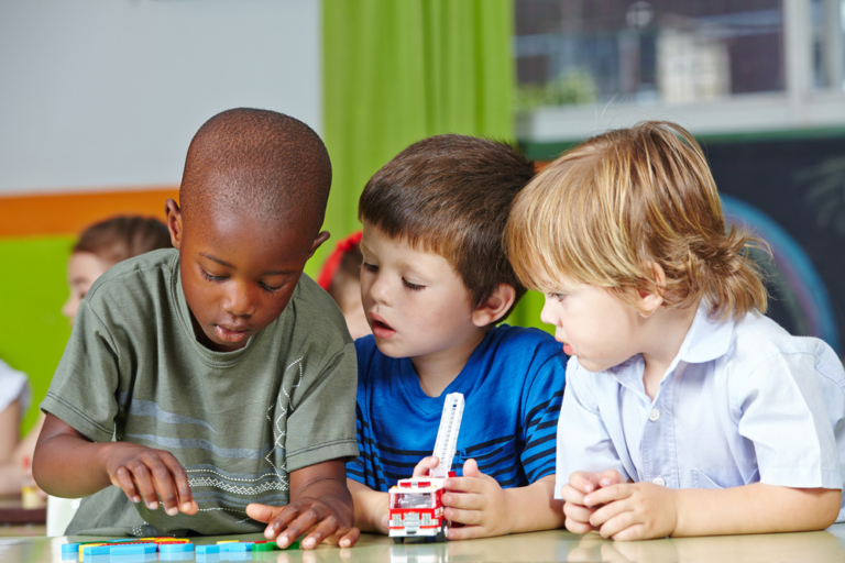 Young children focused on toys, building and exploring.