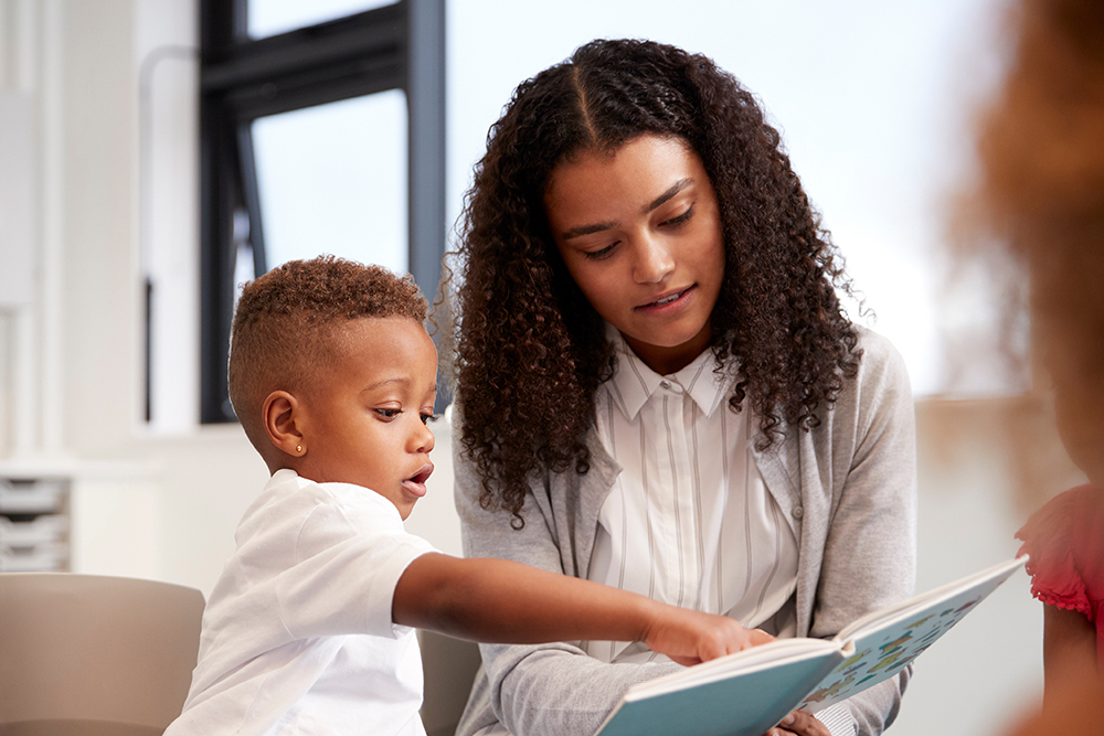 Teacher reading with a young boy.