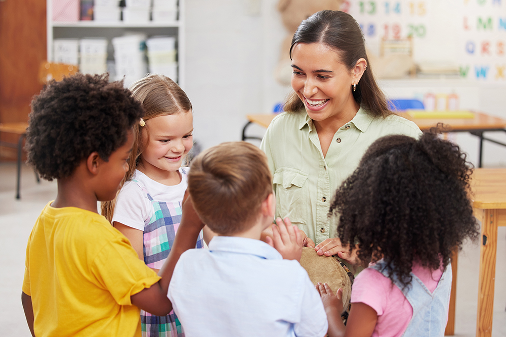 Teacher smiling while talking to a small group of children.